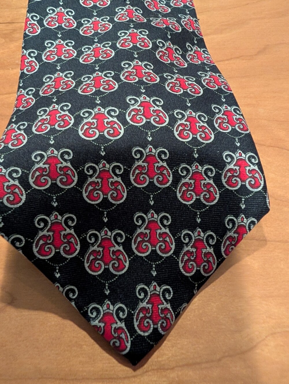 Retro Sharper Image Men's Black Tie with Red Crest Pattern.